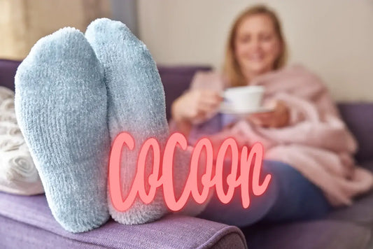 Femme avec des chaussettes polaires à la maison dégustant une tisane